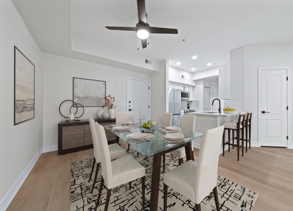 a living room and dining room with a table and chairs